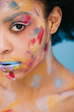 close-up portrait of beautiful young woman with colorful strokes on face on blue clipart