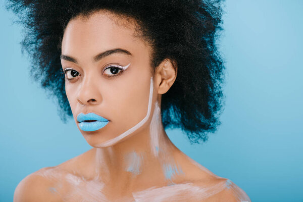 attractive young woman with creative makeup and afro hairstyle isolated on blue