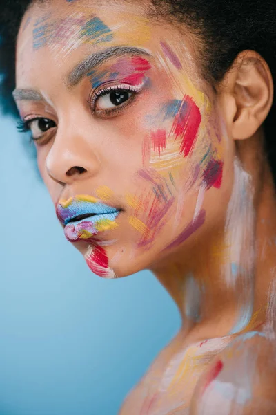Schöne Junge Frau Mit Farbstrichen Gesicht Isoliert Auf Blau — Stockfoto