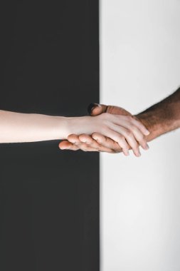 çok kültürlü çift siyah beyaz duvarının yakınında elele kırpılmış