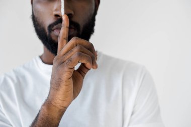 Afro-Amerikan adamın yüzünde beyaz izole sessizlik işaret gösteren beyaz çizgili kırpılmış görüntü