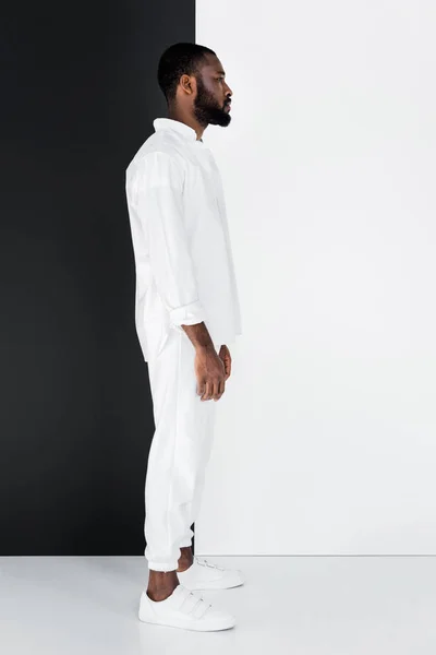 Вид Сбоку Стильного Африканского Мужчины Стоящего Белой Одежде Черно Белой — стоковое фото
