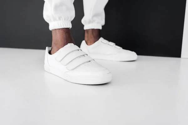 Imagen Recortada Hombre Afroamericano Con Estilo Pie Zapatos Goma Blancos — Foto de stock gratis