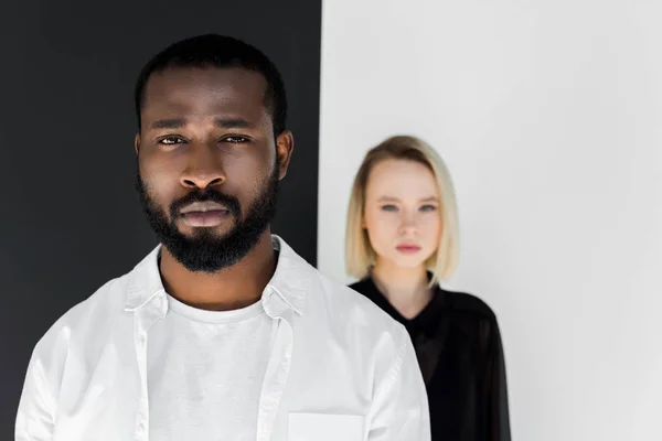 Pareja Multicultural Mirando Cámara Cerca Pared Blanco Negro Yin Yang — Foto de Stock