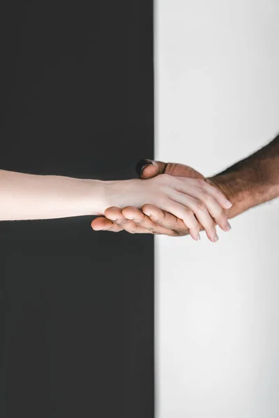 Imagen Recortada Pareja Multicultural Cogida Mano Cerca Pared Blanco Negro — Foto de Stock