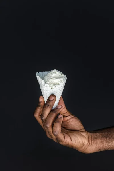 黒に分離された白のアイス クリーム コーンを保持しているアフリカ系アメリカ人のトリミングされた画像 — ストック写真