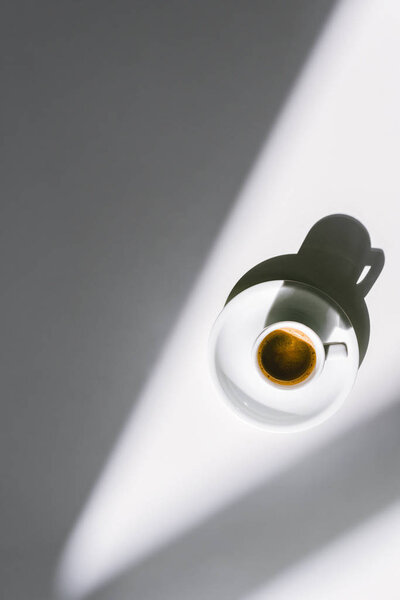 Вид сверху чашки вкусного кофе в белой чашке на белой поверхности
