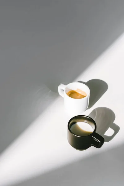 Vista Ángulo Alto Tazas Leche Café Blanco Negro Superficie Blanca — Foto de Stock