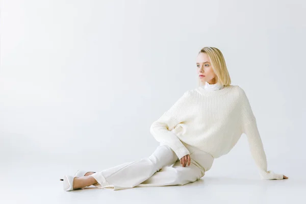 Красива Стильна Блондинка Білому Одязі Сидячи Білій Підлозі Дивлячись — стокове фото