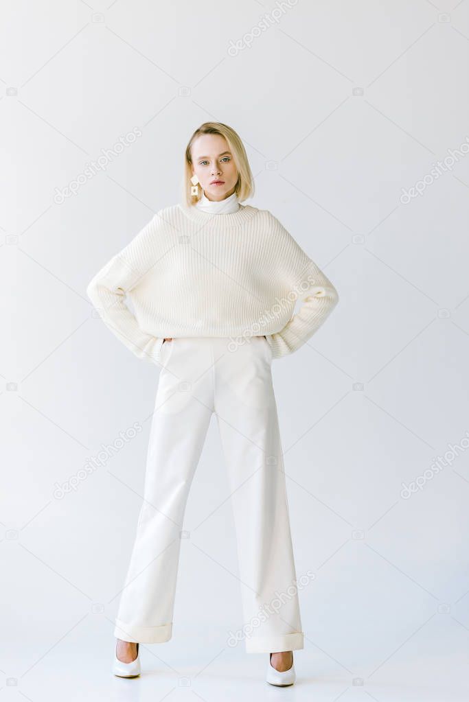 beautiful fashionable blonde woman in white clothes looking at camera isolated on white