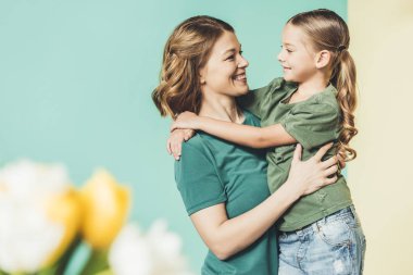 güzel mutlu anne ve sarılma ve birbirlerine gülümseyen kızı yan görünüm