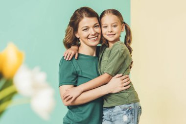 seçici odak güzel mutlu anne ve sarılma ve kameraya gülümseyen kızı