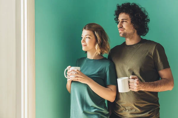 Casal Feliz Shirts Segurando Copos Olhando Para Longe — Fotografia de Stock