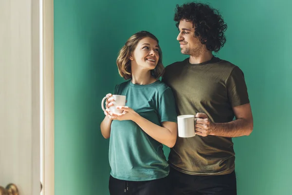Happy Couple Shirts Holding Cups Smiling Each Other — Free Stock Photo