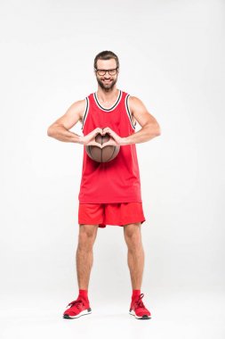 basketbol oyuncusu kalp sembolünü gösterirken topu ile gülümseyen, üzerinde beyaz izole