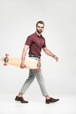 yakışıklı kaykaycı longboard, gri izole ile poz