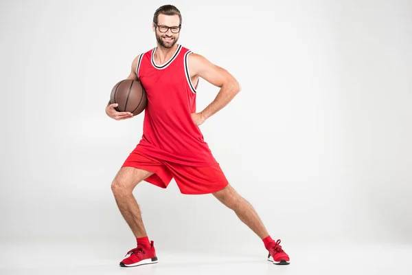 微笑的篮球运动员在红色运动装和复古的杯子摆球 被隔绝在白色 — 图库照片