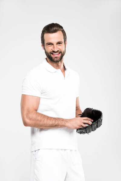 cheerful baseball player with baseball glove and ball, isolated on grey