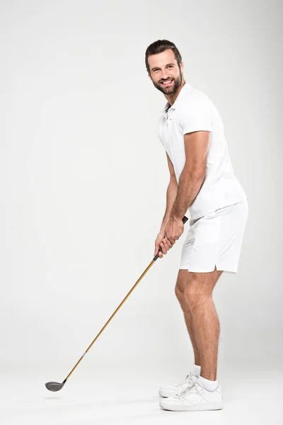 男性高尔夫球运动员在白色运动衫与高尔夫球俱乐部 被隔绝灰色 — 图库照片