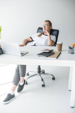 güzel genç iş kadını işyerinde otururken uzağa arıyorsunuz gözlük 