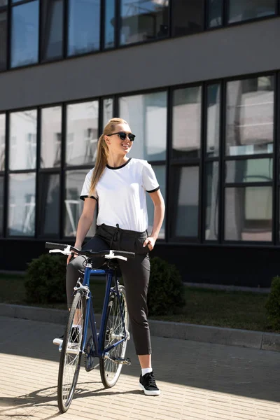 Hermosa Chica Rubia Sonriente Sentada Bicicleta Mirando Hacia Calle — Foto de Stock