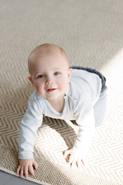 adorable smiling little boy crawling on floor