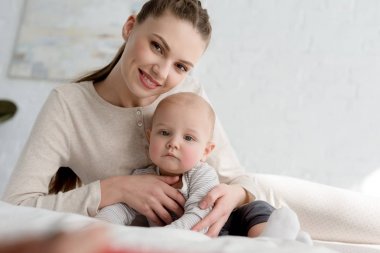 yatakta küçük oğlu ile gülümseyen mumya