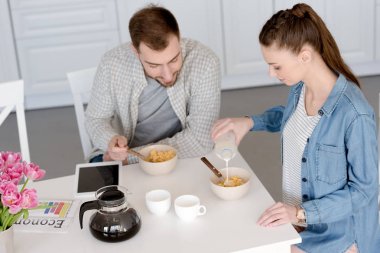 karı koca kahvaltı Mısır gevreği ve kahve ile dijital tablet ile mutfakta