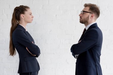 serious businesspeople with crossed arms looking at each other clipart