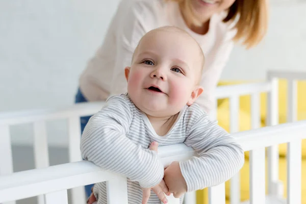 Pouco Sorrindo Filho Berço Bebê Com Mãe Atrás — Fotografia de Stock