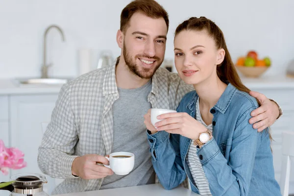 Smiling Couple Cups Coffee Sitting Kitchen — Free Stock Photo