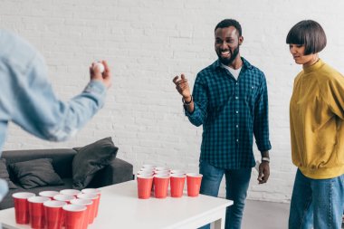 çok ırklı grup bira pong masasında oynayan arkadaşıyla kırpılmış görüntü 