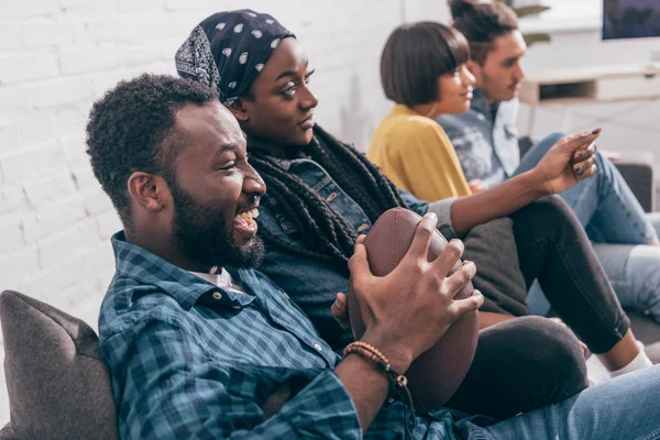 Skrattande Afroamerikanska Mannen Hålla Bollen Och Titta Amerikansk Fotboll Match — Stockfoto