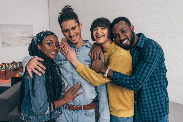 portrait of young smiling group of multiethnic friends embracing each other