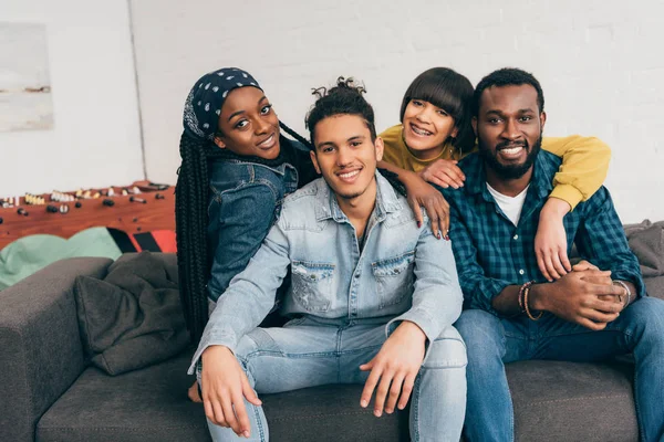 Sorrindo Grupo Jovens Amigos Multiétnicos Abraçando Uns Aos Outros Sofá — Fotografia de Stock