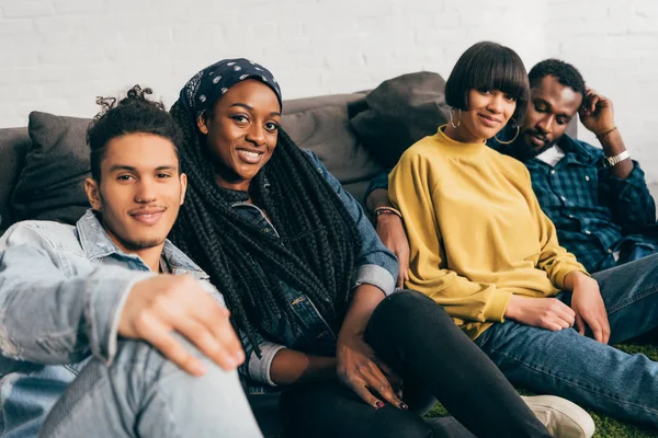 Sorrindo Grupo Jovens Amigos Multiétnicos Sentados Chão Perto Sofá — Fotografia de Stock