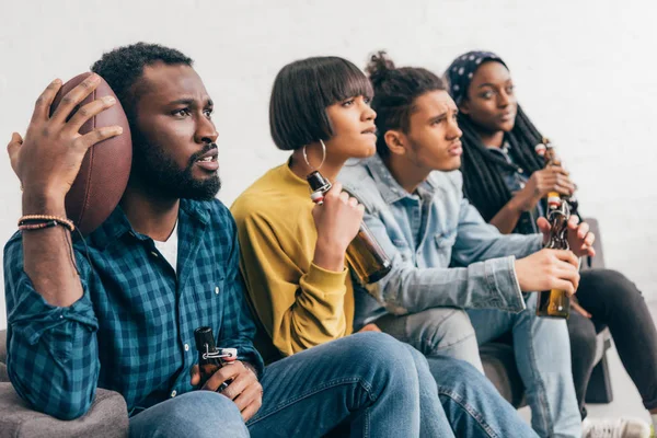 Molesto Grupo Multicultural Amigos Sentados Sofá Con Botellas Cerveza Viendo — Foto de stock gratis