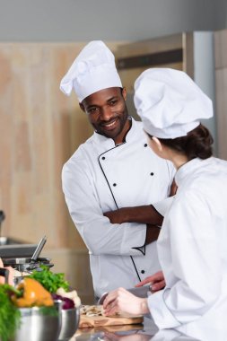 Modern mutfak pişirme sırasında konuşurken aşçıların çok ırklı takım