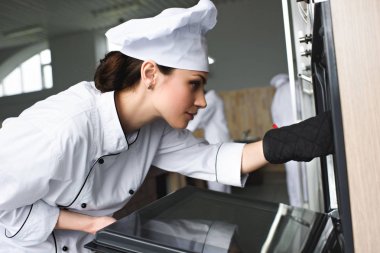 Kadın yemek lokanta mutfağı kontrol fırın fırın