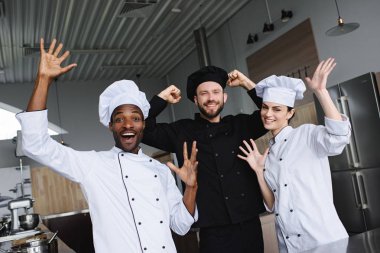 smiling multicultural chefs having fun at restaurant kitchen