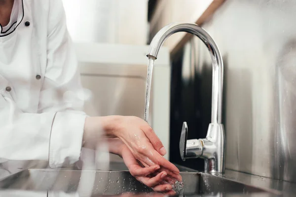 台所の流しで手を洗う女性シェフのビューをトリミング — ストック写真