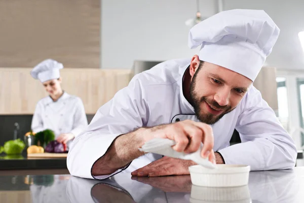 Male Chef Garnishing Dish Restaurant Kitchen Front Female Cook — Stock Photo, Image