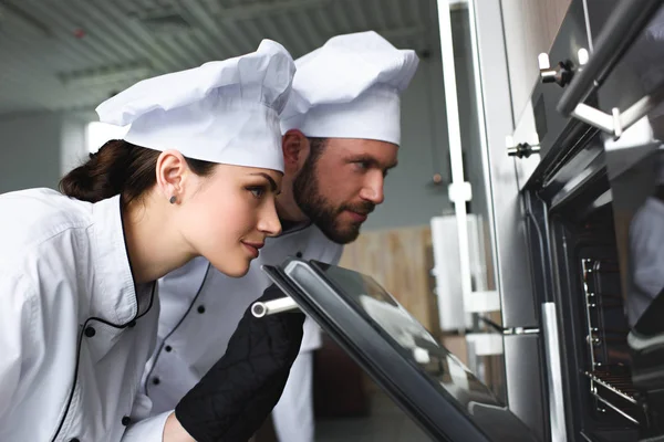 Chef Professionisti Che Guardano Nel Forno Cucina Moderno — Foto Stock