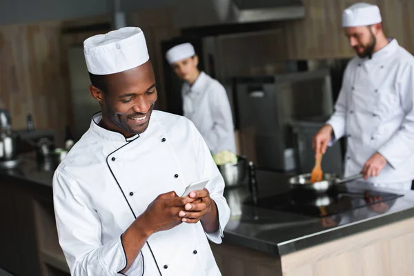 Zâmbind African Bucătar American Folosind Smartphone Bucătărie Restaurant — Fotografie, imagine de stoc