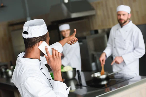 Africký Americký Šéfkuchař Mluví Smartphone Ukazuje Palec Kolegové Restauraci Kitchen — Stock fotografie