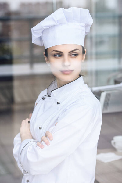 attractive chef looking away at restaurant kitchen