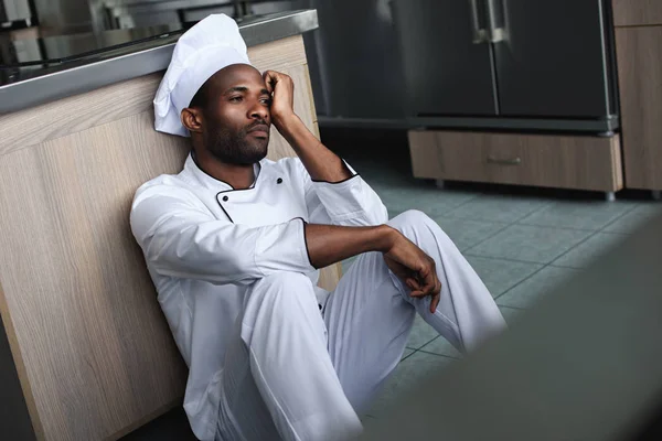 Zmęczony African American Szefa Kuchni Siedzi Podłodze Kuchni Restauracji Szukasz — Zdjęcie stockowe