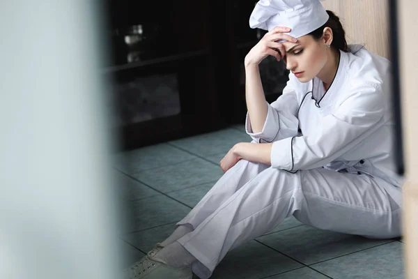Θλιβερή Σεφ Κάθεται Στο Πάτωμα Στην Κουζίνα Εστιατορίου — Φωτογραφία Αρχείου