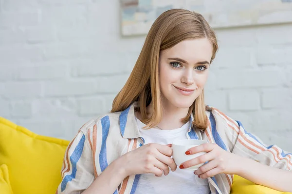 Sorrindo Jovem Mulher Elegante Sentado Sofá Com Xícara Café — Fotografia de Stock