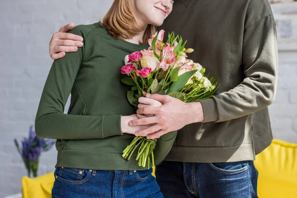 Immagine Ritagliata Dell Uomo Che Abbraccia Sorridente Fidanzata Con Fiori — Foto stock gratuita